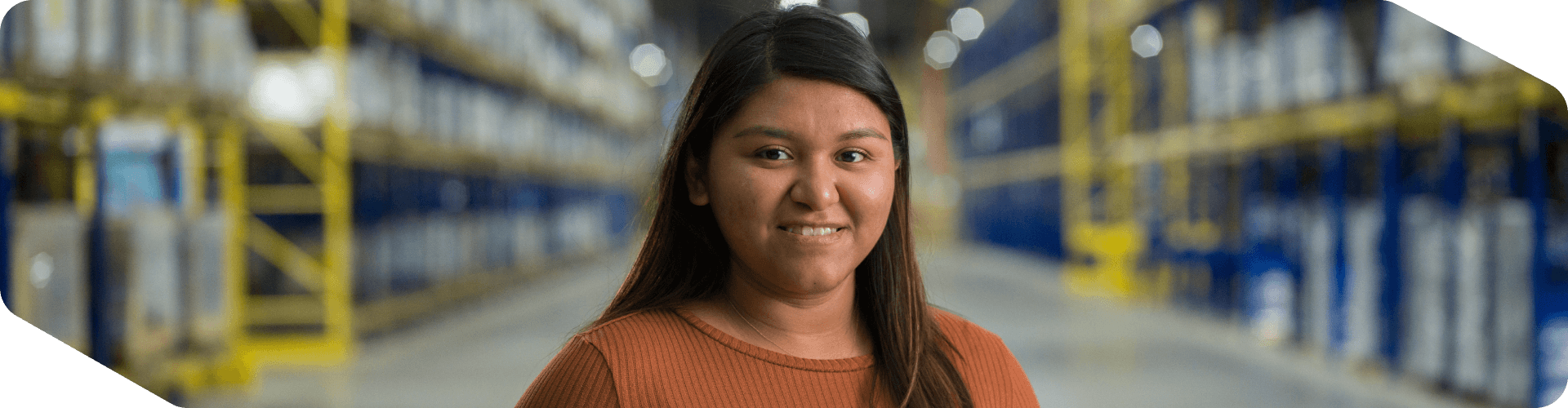 Supply Chain associate standing confidently in a warehouse