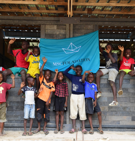 Children holding the MSC Foundation flag, symbolising the Foundation’s global humanitarian impact