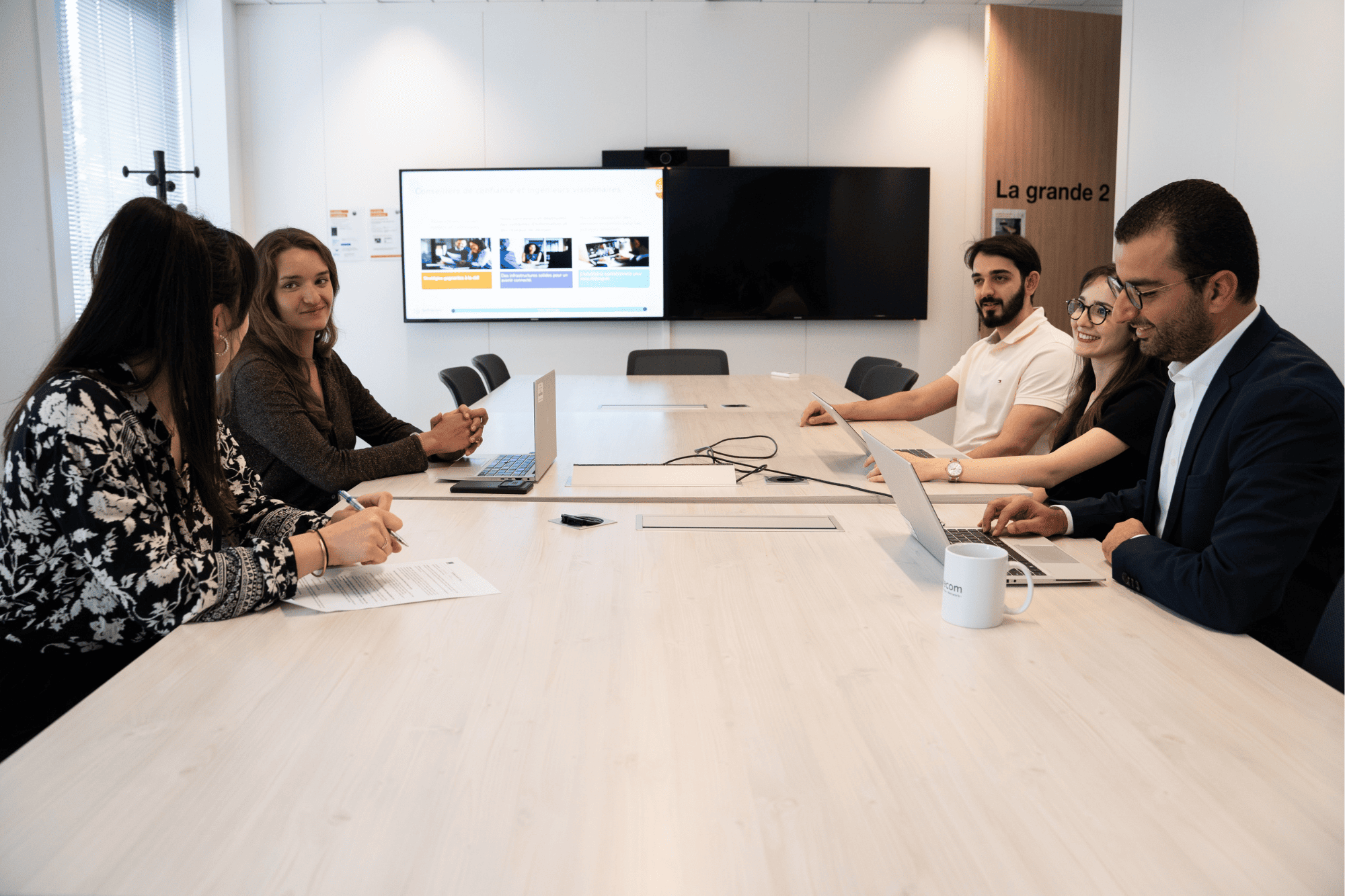 Our team engaging in a strategic session within a modern, tech-equipped conference room at the Orange Sofrecom offices.
