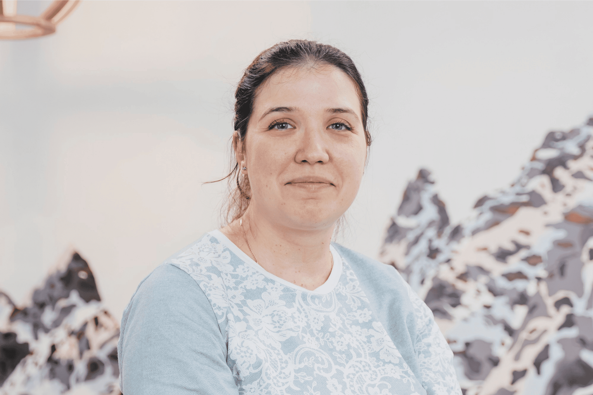 Portrait of a woman standing indoors, looking at the camera in a professional setting