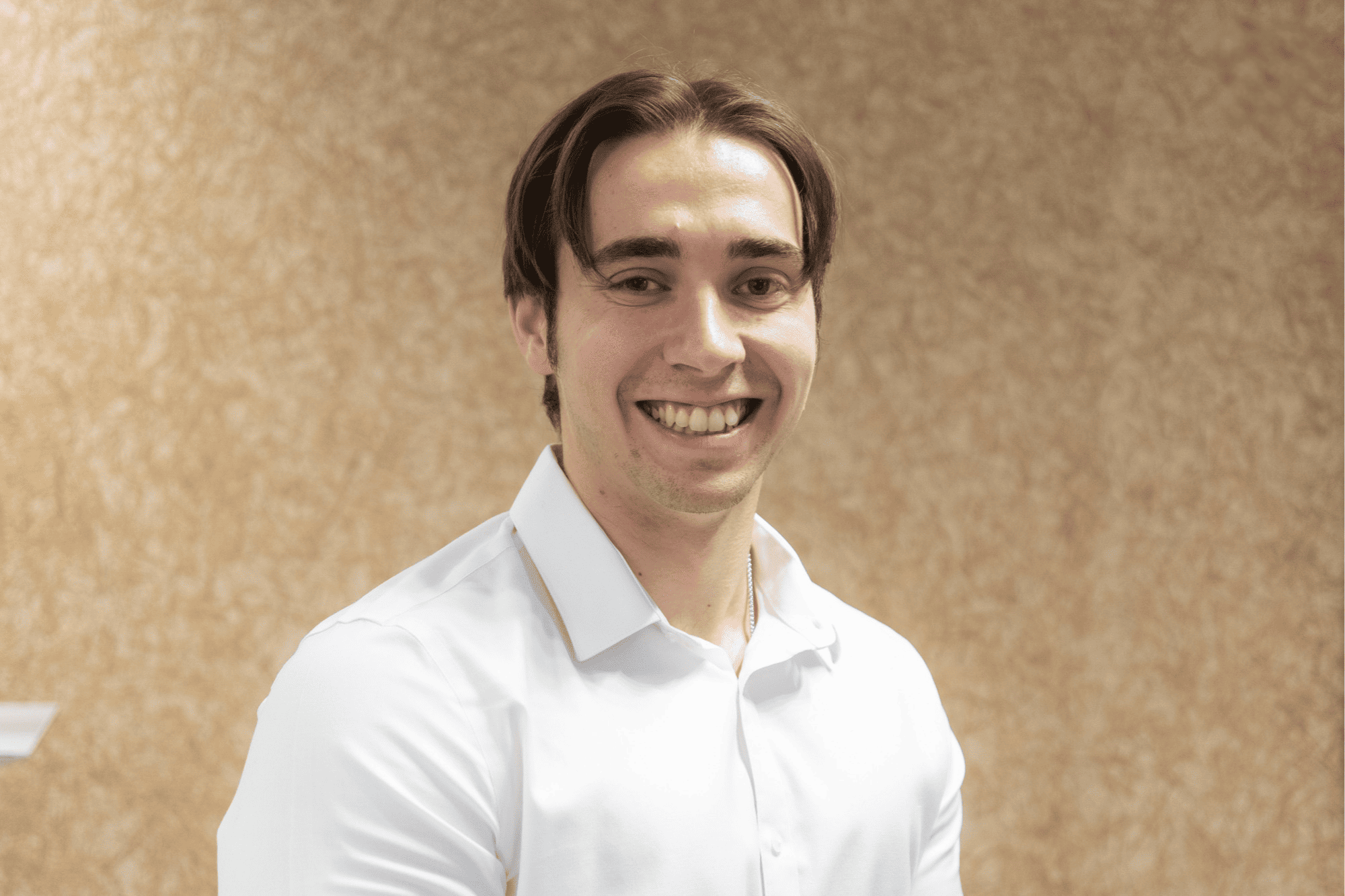 Headshot of Steven, an Incident Manager, smiling in a white shirt against a neutral textured office wall.
