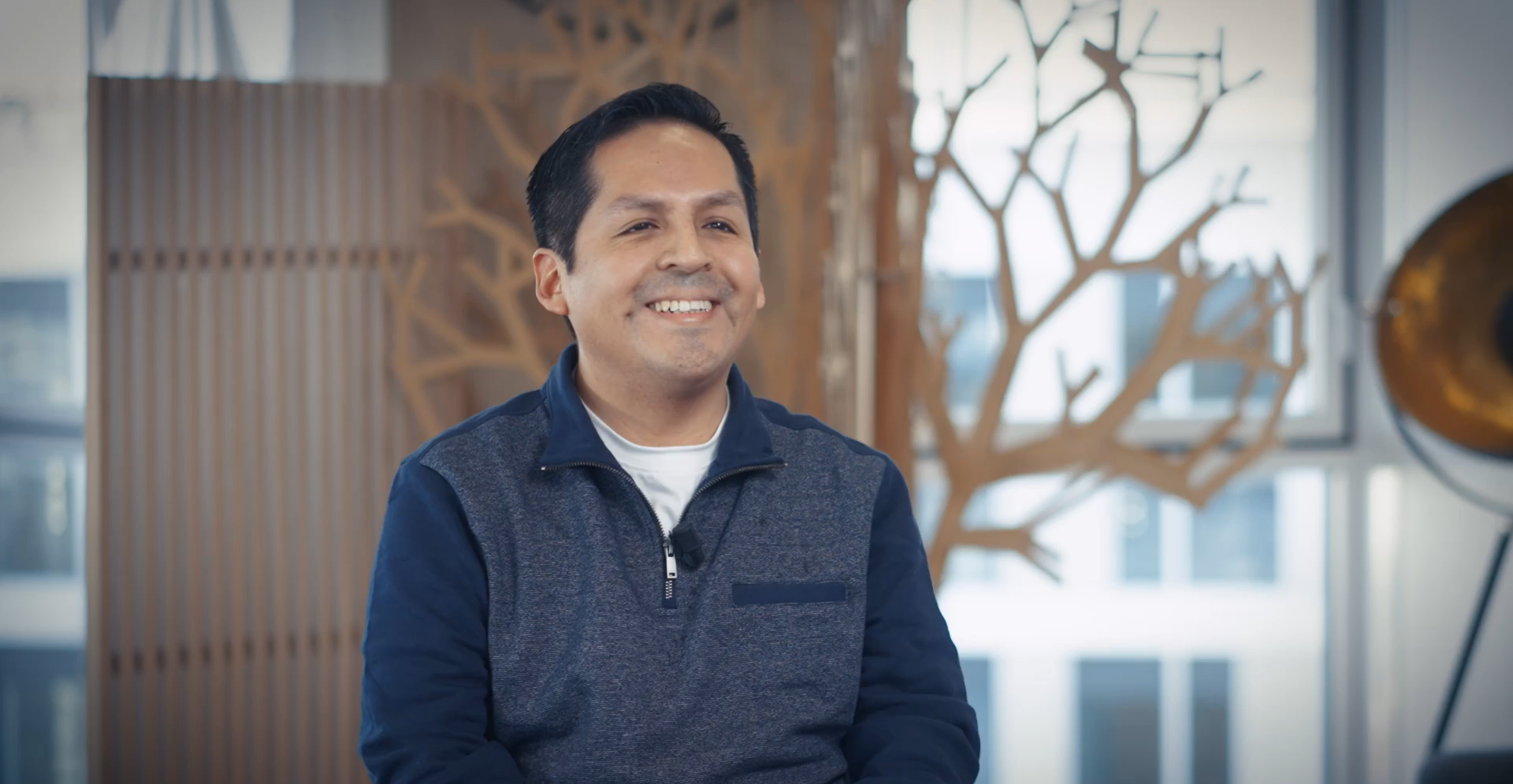 A professional photo of Abraham, a PhD student in Artificial Intelligence, working on his thesis, smiling in a collaborative research setting.