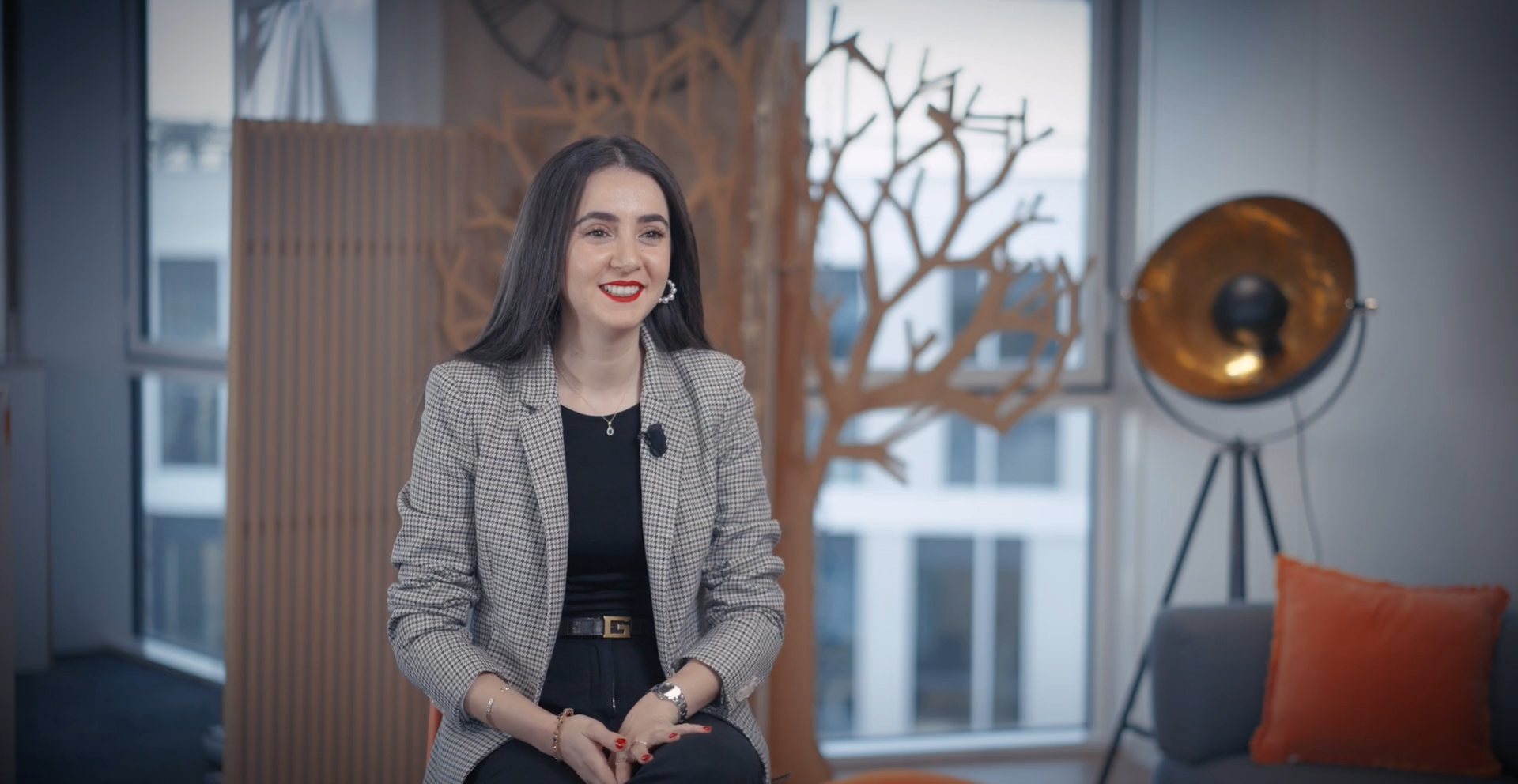 A warm, professional portrait of Amel, a PhD student in networks and telecommunications, in a bright academic or corporate research environment.