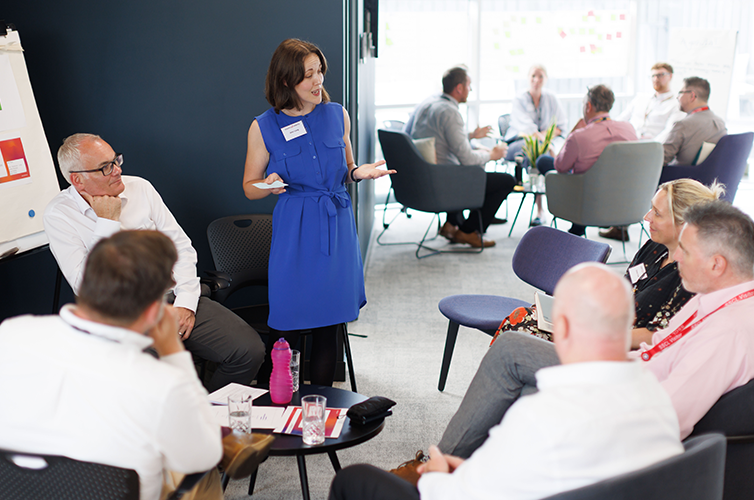 A woman standing to address a group of people
