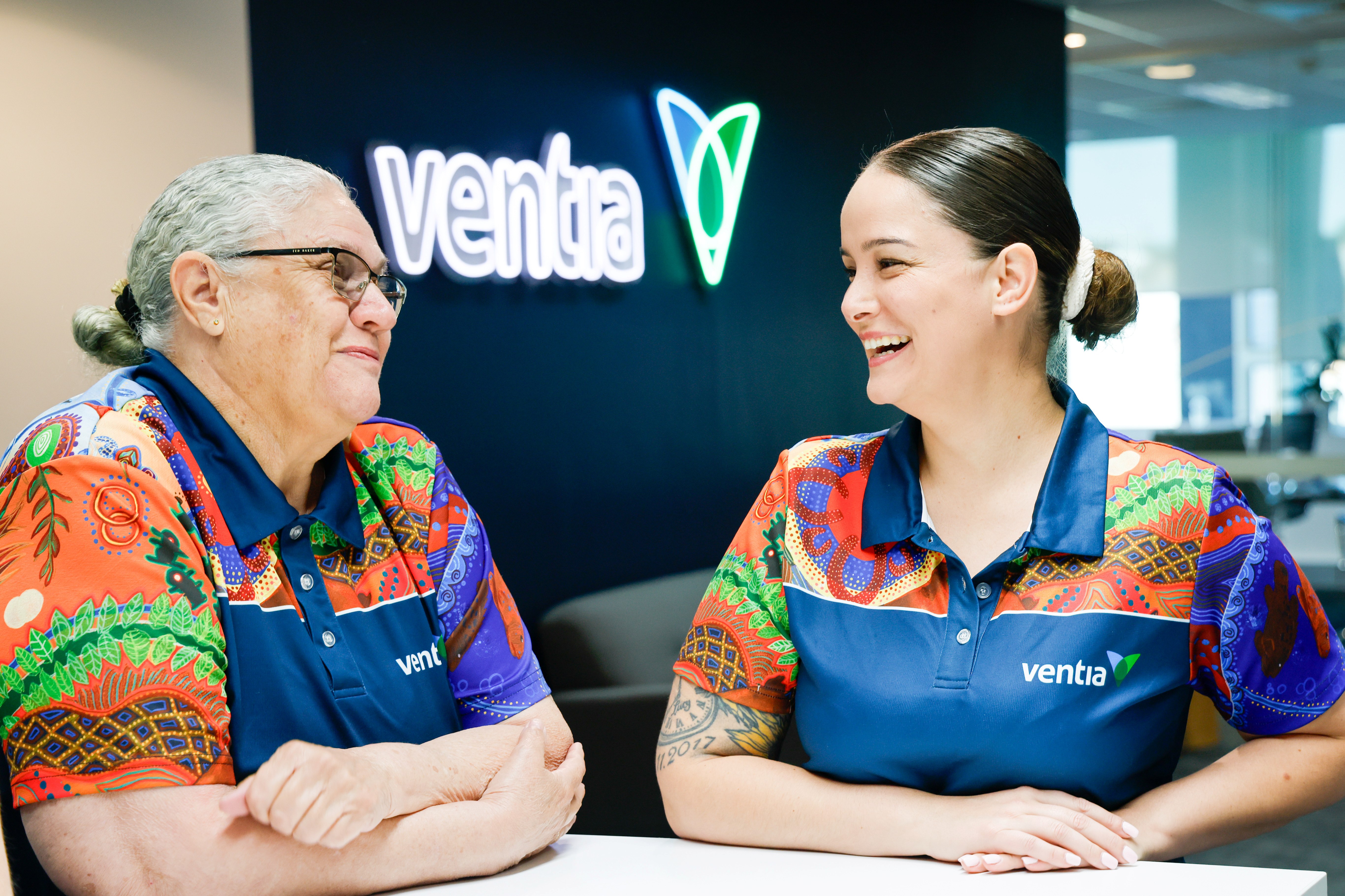 two people smiling in colourful shirts